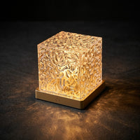 Givre crystal lamp casting a rippling amber light pattern across a dark room